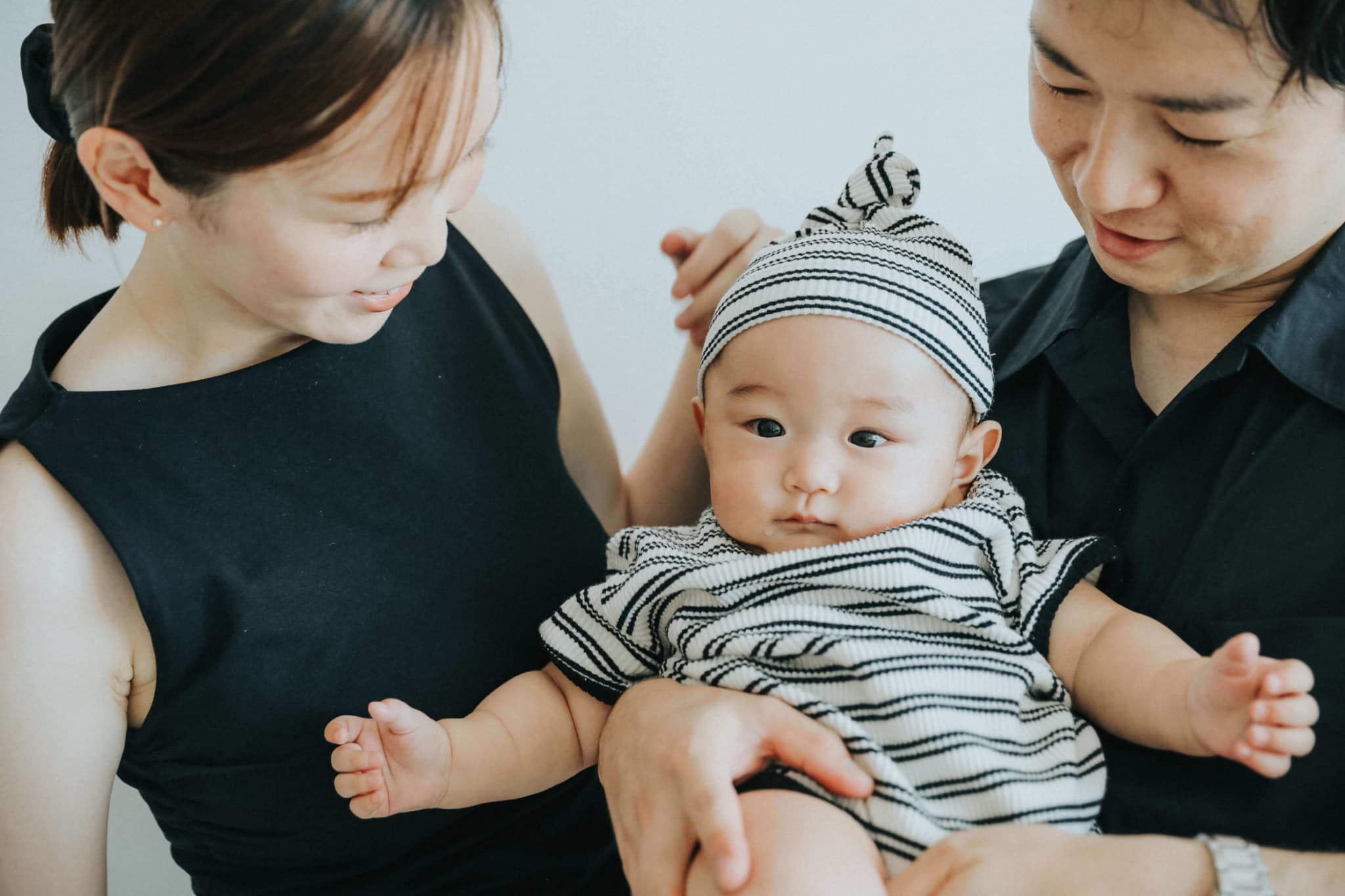フォトスタジオでお宮参りの記念撮影をする赤ちゃんとご家族の写真